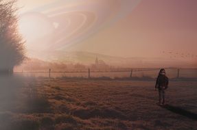 man in the meadow on the background of the ring of Saturn