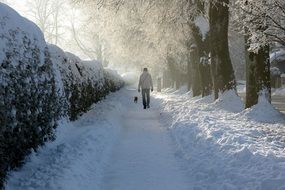 man goes through the snowy footpath