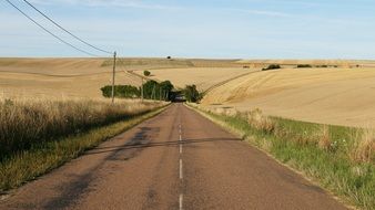 asphalt road among fields in france