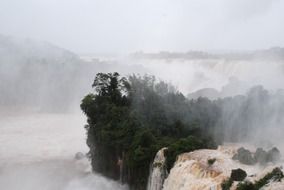 Fog and spray over Iguazu Falls with plants in Argentina