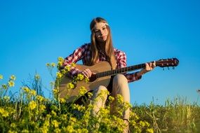 girl playing guitar in nature