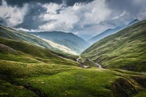 panoramic view of green mountains in cloudy haze