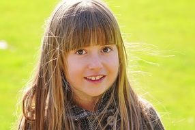 little girl face portrait in the meadow