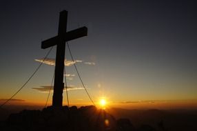 Silhouette of the cross on the summit against the beautiful and colorful sunrise