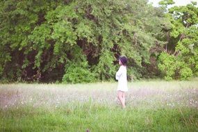 Girl on the field near the forest