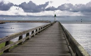 wooden pier to the lighthouse on the lake