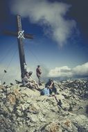 people near the cross on top of the alps