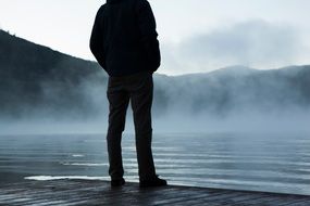 man on a lake jetty