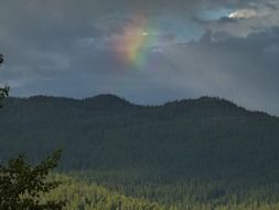 rainbow after thunderstorm on dark sky