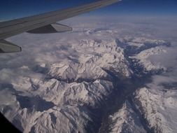 view from the plane on the snowy mountains of Switzerland