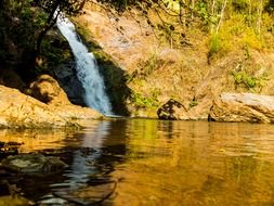 waterfall on a cliff above the river in northern thailand