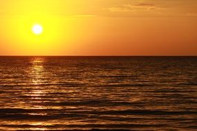 bright orange sky with the sun over the sea