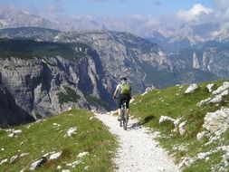 cyclist with a backpack on a path in the mountains of south tyrol