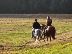 People are riding on the horses on the field