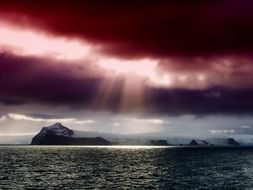 the sun through the burgundy clouds in Antarctica