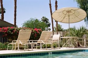 Sun loungers and beach umbrellas at the edge of the pool at the hotel