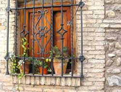 wrought iron grille and wooden window shutters in Spain