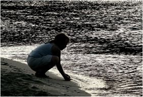 human silhouette sitting near sea water