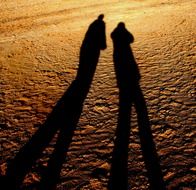 shadow of two people on the sand