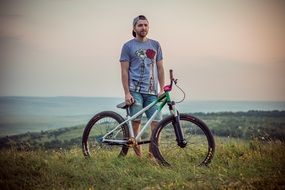 young man with the bike in the Field