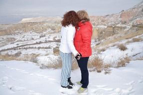 women's pair on a snowy mountain in Cappadocia