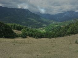 valleys and mountains in the background of the cloudy sky