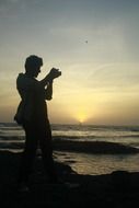 photographer near the water at dusk