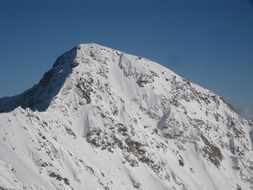 snowcaped mountain peak at blue sky on a sunny day