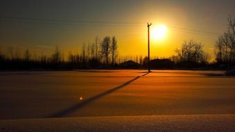 snowy road in the rays of a golden sunset