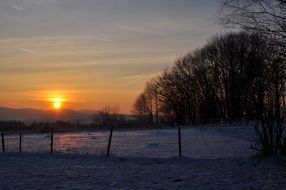 panorama of rural fields in winter against the sunset