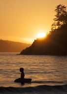 silhouette of a man in the sea at sunset