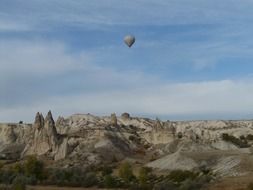 Hot air balloon over rocks, Turkey, Cappadocia