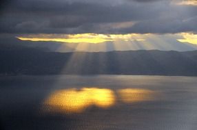 sun rays water setting clouds