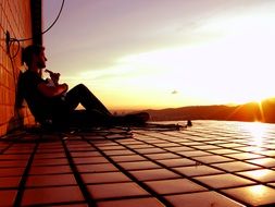 guitarist on a roof at sunset in asia