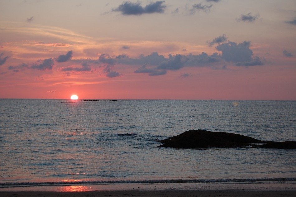 red sun at sunset on the ocean horizon