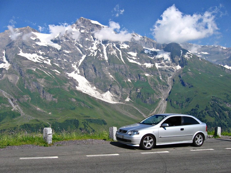 Opel car on the road against the backdrop of the mountains