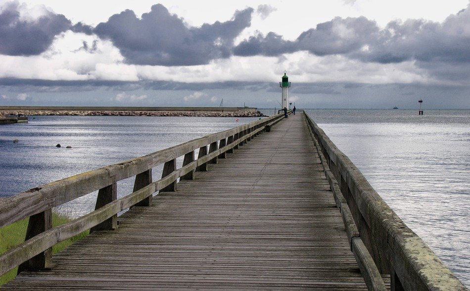 wooden pier to the lighthouse on the lake