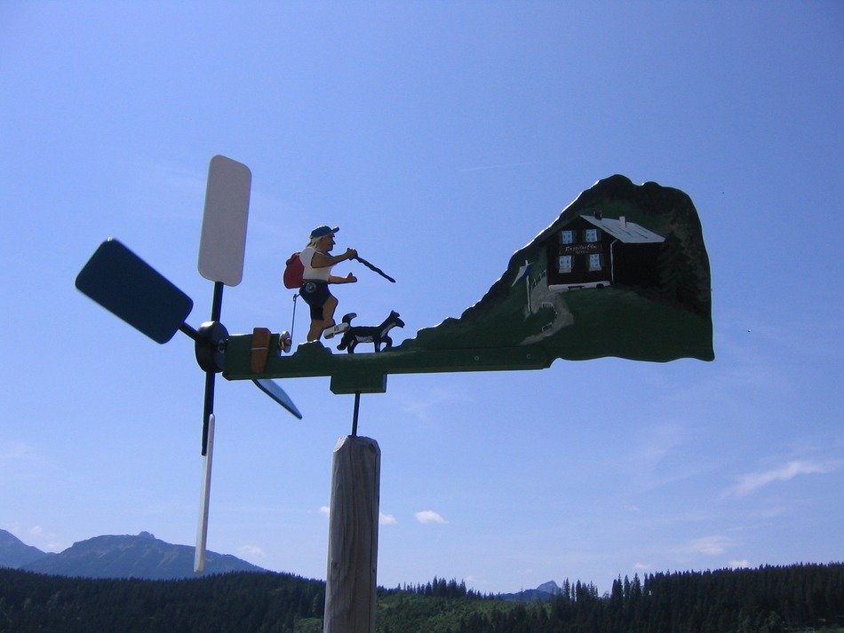 funny tourist, wind vane at mountain landscape