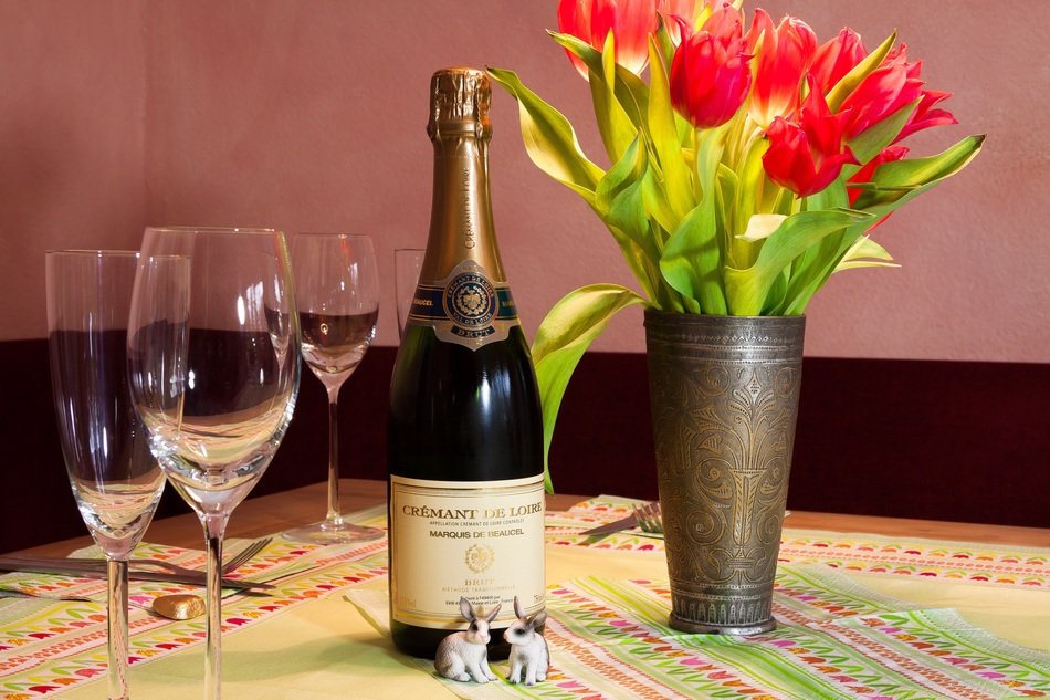 tulips, glasses, rabbit figurines and champagne cremant de loire marqis de neausei brut