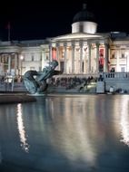 fountain in front of national gallery on trafalgar square at night, uk, england, london