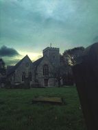 stone church in a cemetery at dusk