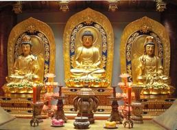three golden Bodhisattva statues in a temple in China