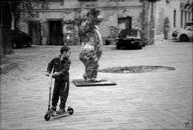 child boy riding scooter in yard