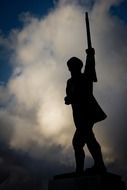 silhouette of a statue at dusk