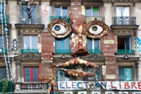 Face made of metal on facade wall of the building in France