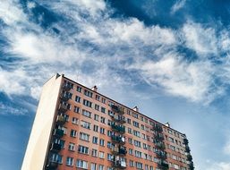 sky with white clouds over an apartment building