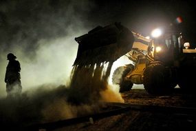 bulldozer works on construction site at night