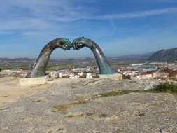 hands like a sculpture on a cliff above the city of Xativa