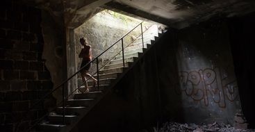 woman on ruined stairs in the dark