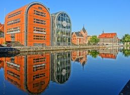 colorful buildings are reflected in the river in bydgoszcz